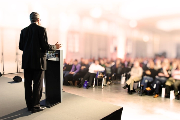 Men standing in front of audience holding a lecture