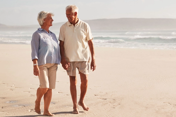 Senior couple walking at the beach